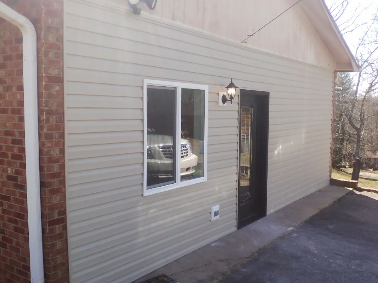 New vinyl siding and entry door on a room addition in Carmen