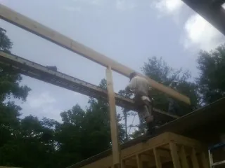 Carpenter setting a ridge beam over a new addition frame — Ice Dam Removal by Roofing Brothers in Carmen