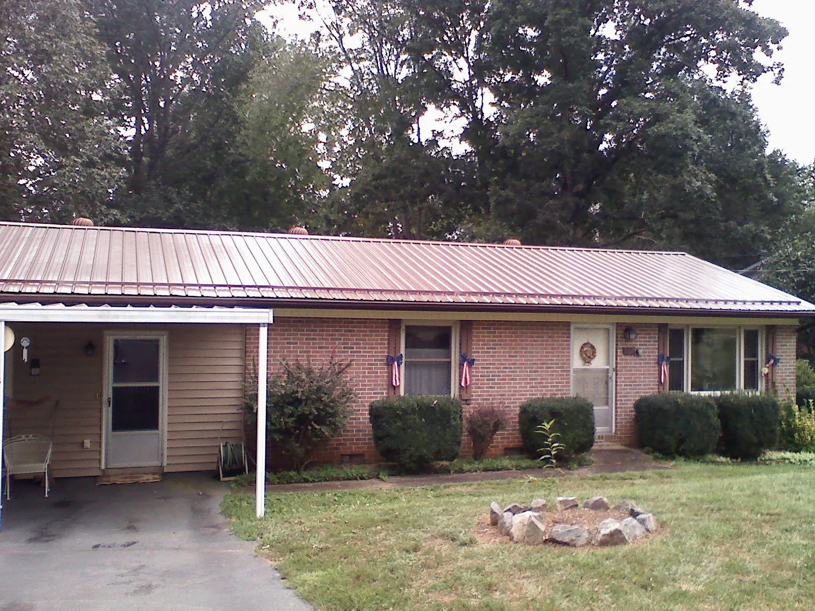 Bronze metal roof and carport on a brick ranch home — Roof Repair work by our crew in Carmen